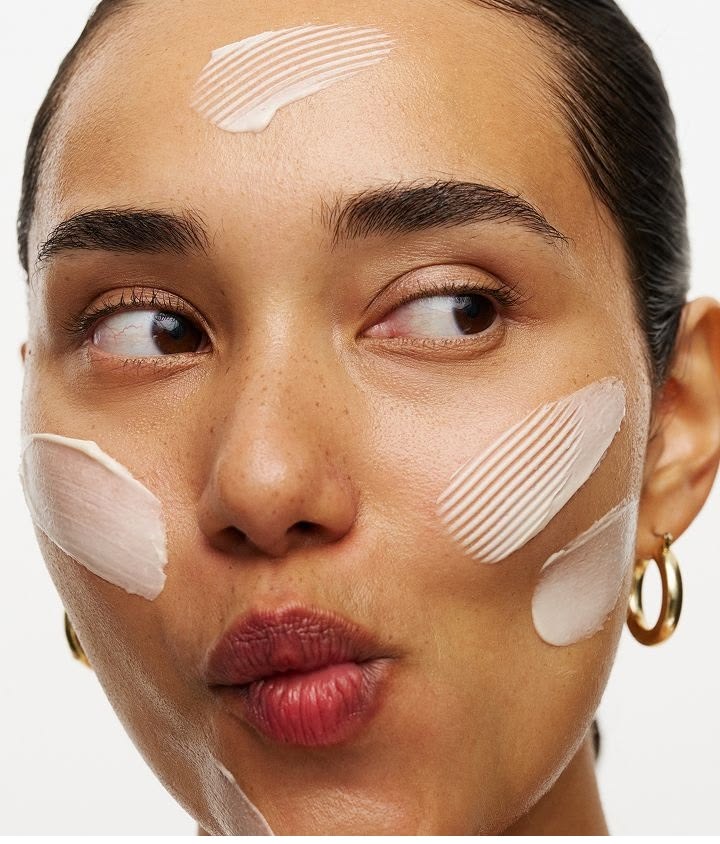 Close-up portrait of a woman with facial cream applied to her forehead and cheeks