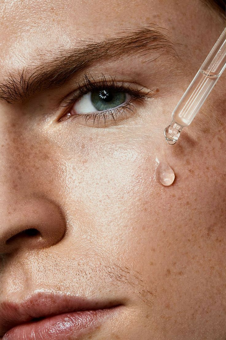 Serum dropper applying a clear drop to the cheek