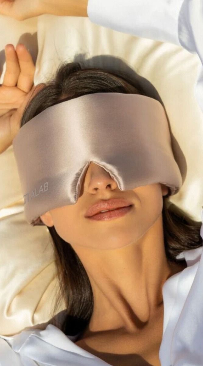 Woman resting on a pillow wearing a sleep mask